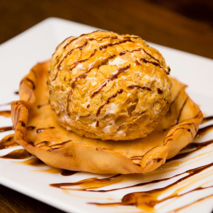 Fried ice cream with a cornflake crust, drizzled with chocolate and caramel, served in a tortilla bowl.