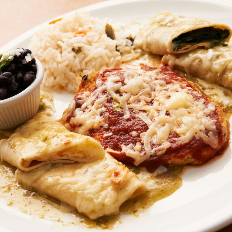 Acapulcos Mexican combo plate with cheesy enchiladas, rice, and black beans on a white plate.