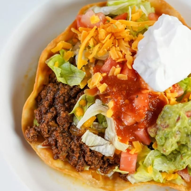 Acapulcos' taco salad with ground beef, lettuce, cheese, tomatoes, salsa, guacamole, and sour cream.